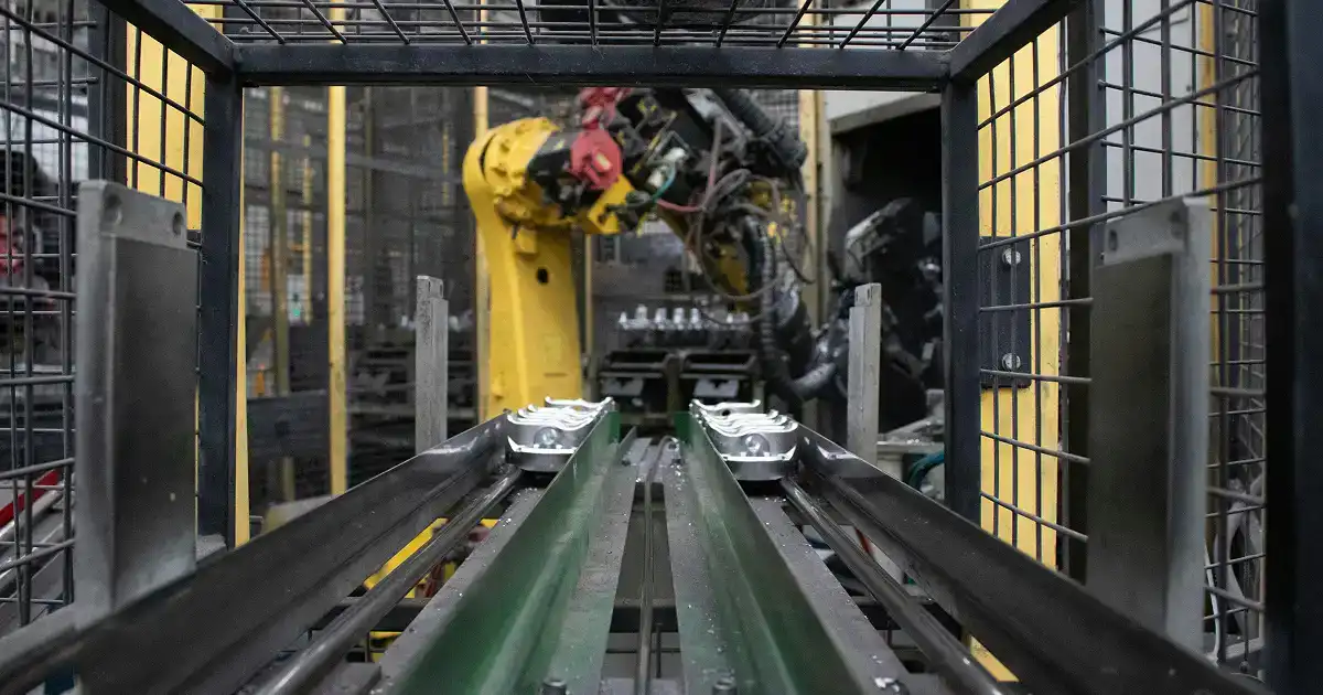 Różne rodzaje paletyzatorów na hali produkcyjnej